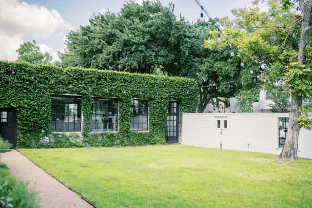 Carriage House venue with lush greenery, ideal for outdoor events and gatherings.