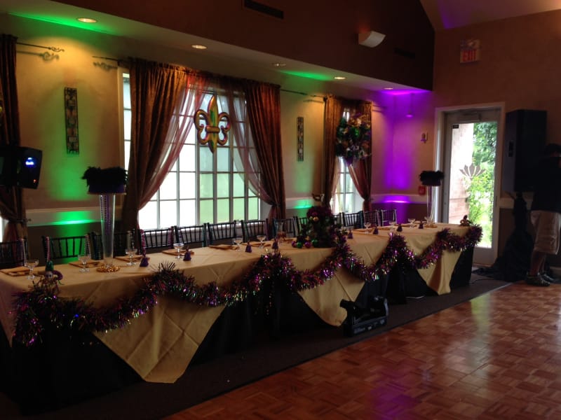 Corporate event setup with elegant gold tablecloth and vibrant lighting at Cinco Ranch Golf Club.