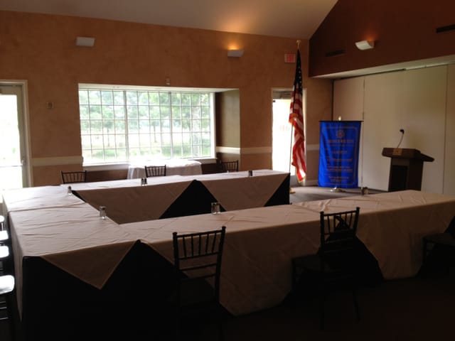 Corporate meeting setup with tables and natural light at The Golf Club, Cinco Ranch.