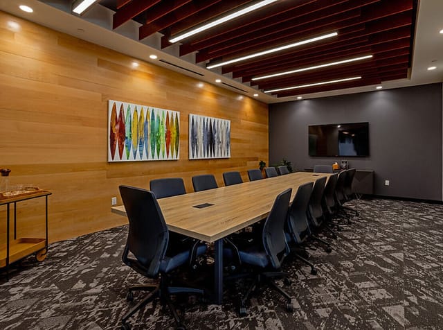 Modern conference room with wooden table and ergonomic chairs, ideal for meetings in Houston.