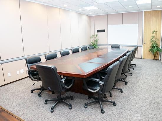 Professional conference room with wooden table, ideal for meetings and strategy sessions.