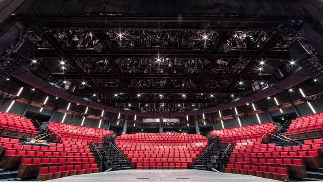 Modern amphitheater with red seating, ideal for events and performances in Alley Theatre.