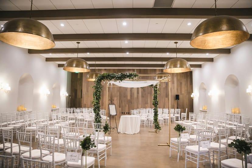 Elegant ceremony space at The Hall on Dragon with gold lighting, perfect for weddings.