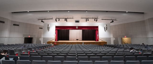 Houston auditorium with red curtain backdrop, ideal for conferences and presentations.