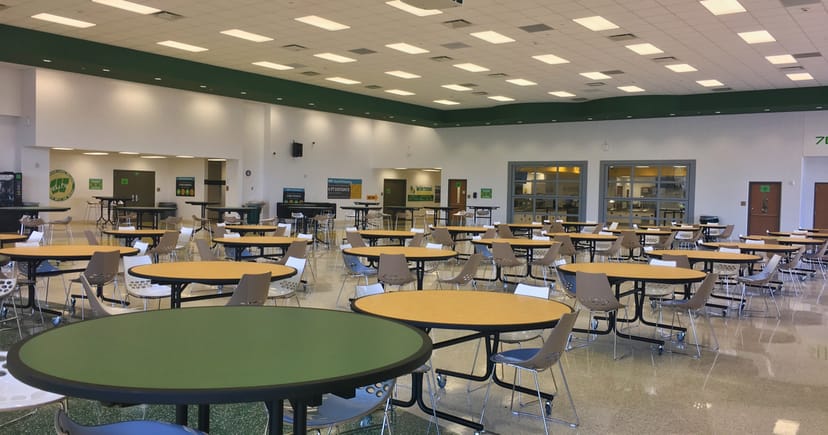 Flexible cafeteria event space in Houston with round tables for meetings and gatherings.