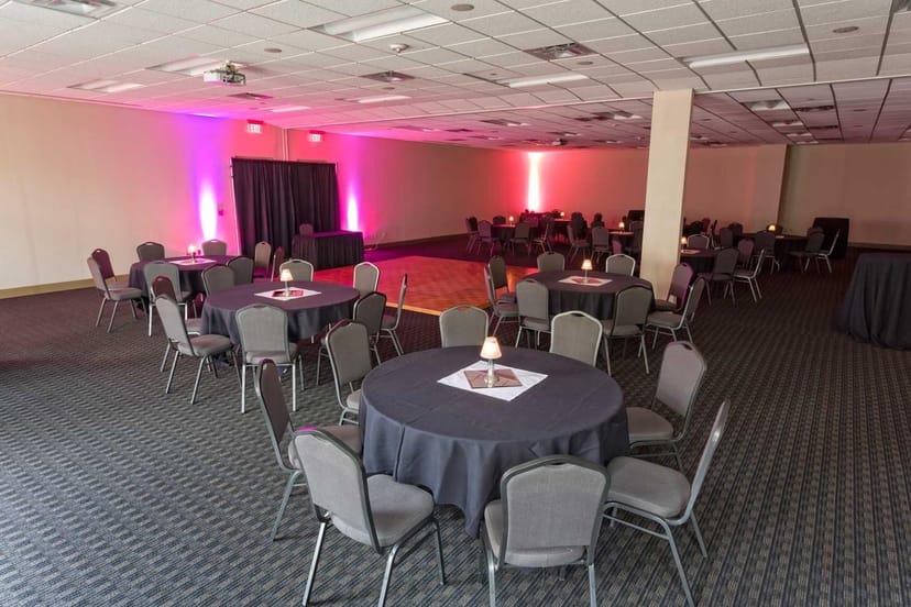 Event Facility in Red Oak Ballroom with round tables and soft pink lighting for gatherings.