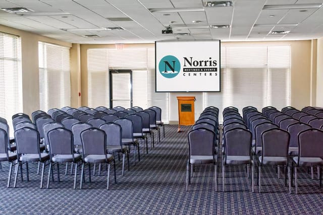 Alt text: Red Oak Ballroom conference setup with chairs and large screen for corporate events.