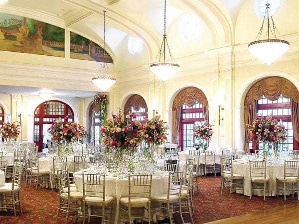 Elegant banquet hall in Crystal Ballroom with tall floral centerpieces for formal events.