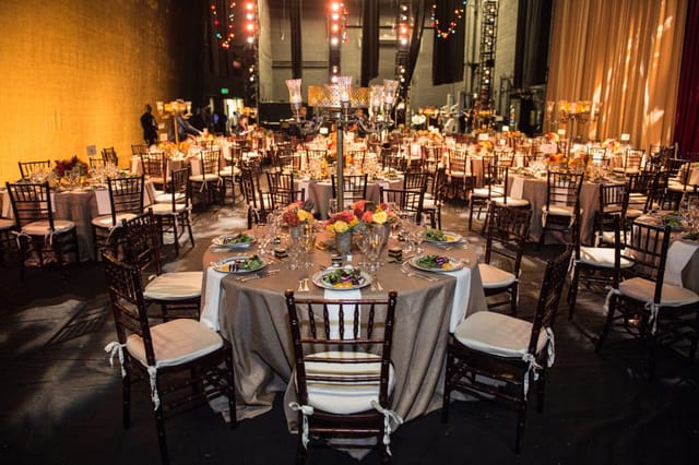 Elegant banquet hall setup for upscale events, featuring round tables and floral centerpieces.