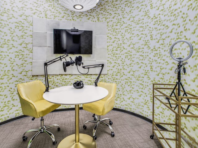 Modern conference space with round table, perfect for hybrid meetings and content creation.
