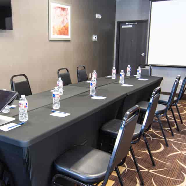 Conference room with long black table, ideal for workshops in Houston Women's Center.