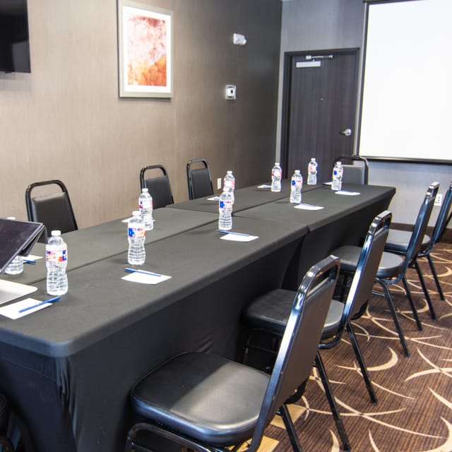 Conference room with long black table, ideal for workshops in Houston Women's Center.