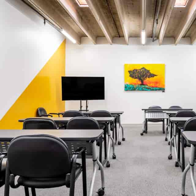 Modern training room in Houston with yellow wall, ideal for workshops and meetings.