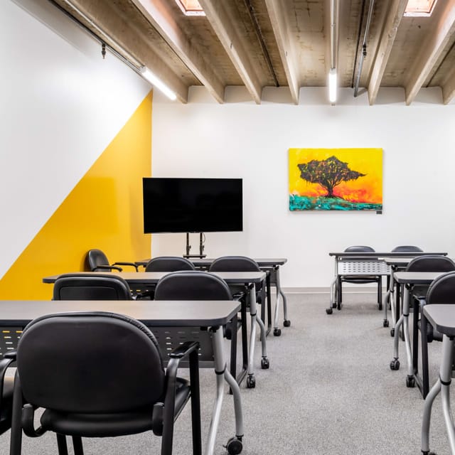 Modern training room in Houston with yellow wall, ideal for workshops and meetings.