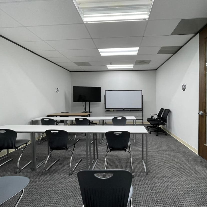Modern training room with tables and chairs, ideal for workshops and meetings in Houston.