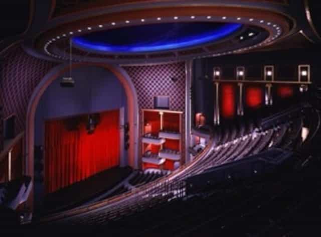 Theater with red curtains and tiered seating for performances at Hobby Center