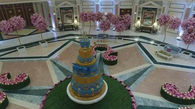 Wedding venue at The Ritz-Carlton Riyadh with elegant floral decor and tiered cake.