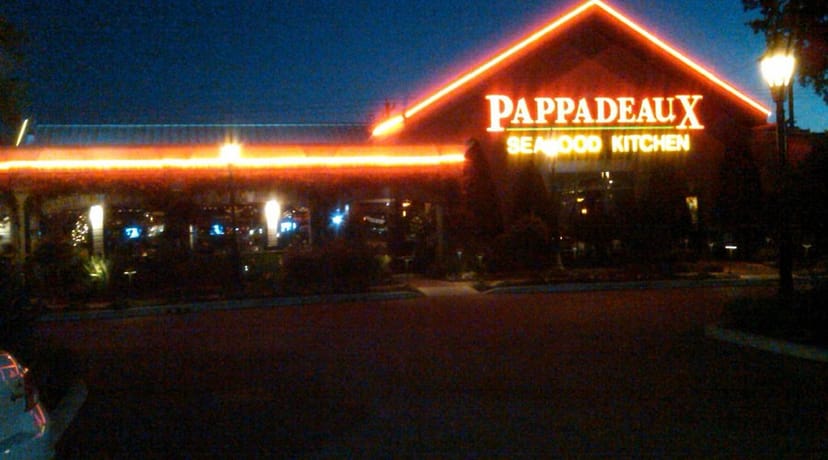 Pappadeaux Seafood Kitchen exterior at dusk, vibrant neon sign for casual dining events.