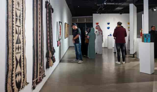Art exhibition at Gallery Naila showcasing diverse artworks and textiles for networking events.