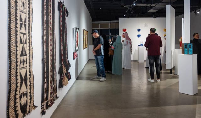 Art exhibition at Gallery Naila showcasing diverse artworks and textiles for networking events.