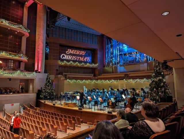 Holiday concert stage at Meyerson Symphony Center with festive "MERRY CHRISTMAS" decor.