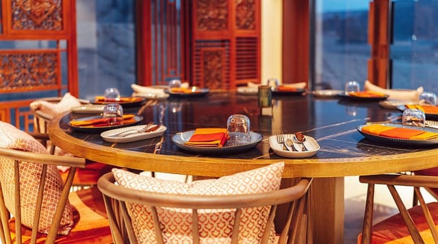 Elegant round dining table in Saffron Roots for corporate events and exclusive dinners.