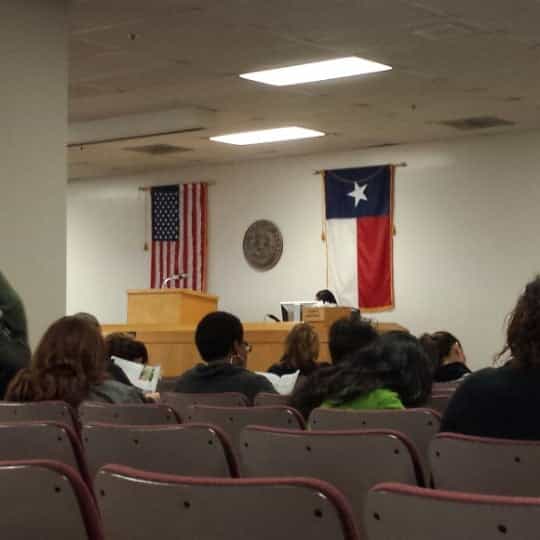 Dallas County Jury Room courtroom with attendees, flags, and professional event setup.