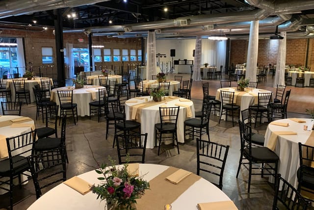 Elegant 1st Floor Commerce Room with white tables for corporate events and weddings.