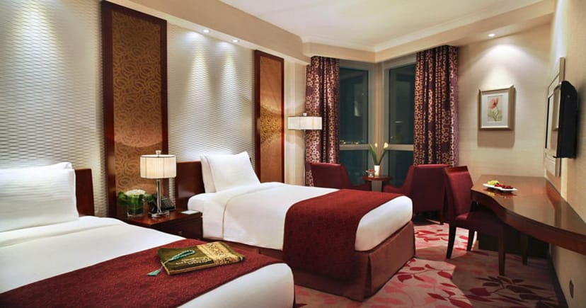 Twin-bedded hotel room at Al Bayt, ideal for events and professional gatherings.