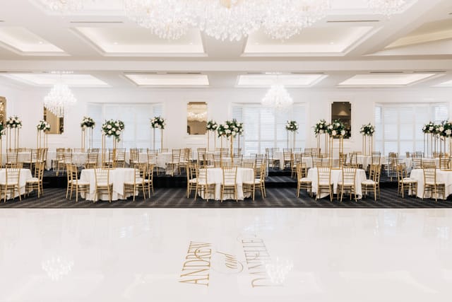 Elegant wedding venue with floral centerpieces and a dance floor in Bliss Room, Sheldon Reception.