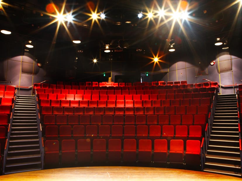 Alt text: "Main auditorium at Zenith Theatre with tiered red seating, perfect for events and performances."