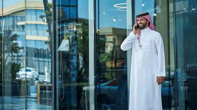 Professional on a phone outside modern Servcorp venue, perfect for networking events.