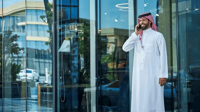 Professional on a phone outside modern Servcorp venue, perfect for networking events.