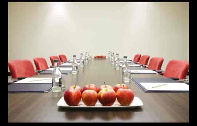 القاعة الماسية meeting room with long table, red chairs, ideal for events and discussions.