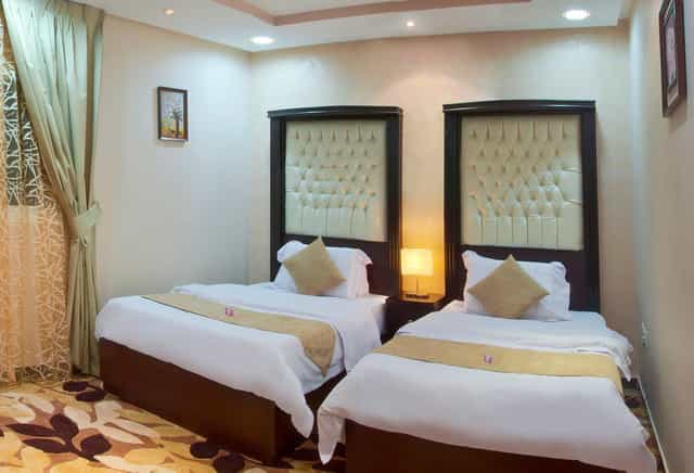 Elegant hotel room with twin beds, perfect for conference attendees' lodging.