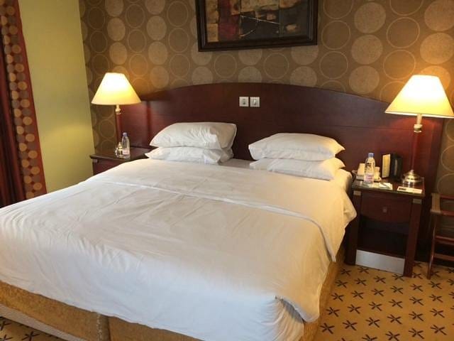 Luxurious hotel room with king-size bed, perfect for corporate retreats or relaxation.