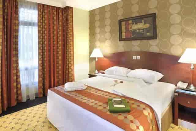 Luxurious hotel room with inviting bed, ideal for business meetings and events.
