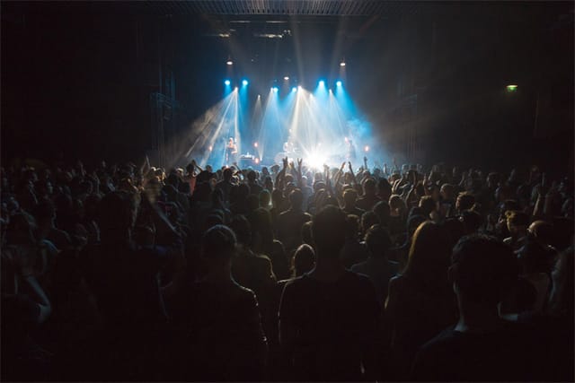 L'Épicerie Moderne concert with enthusiastic audience and dramatic lighting ambiance