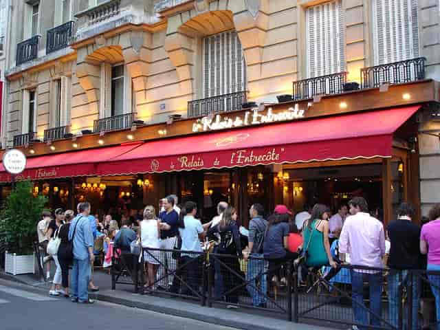 Bustling outdoor café at Le Relais de l'Entrecôte, perfect for casual networking events.