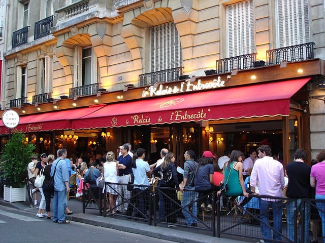 Bustling outdoor café at Le Relais de l'Entrecôte, perfect for casual networking events.