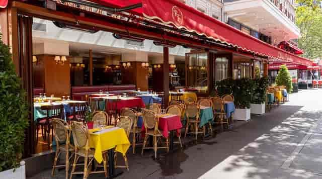 Charming outdoor dining at Le Relais de l'Entrecôte with colorful tablecloths for casual events.