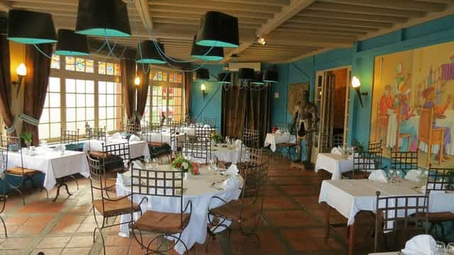 Elegant dining space with white linens at La Tablée Médiévale, perfect for events and celebrations.