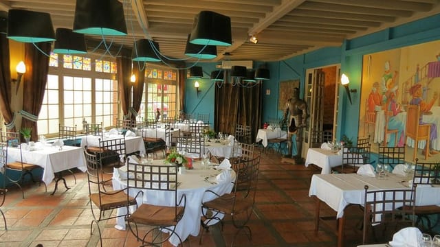 Elegant dining space with white linens at La Tablée Médiévale, perfect for events and celebrations.
