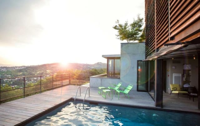 Modern outdoor event spaces at La Maison, Ermitage Hotel with inviting pool and lounge chairs.
