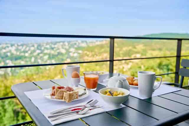 Outdoor networking breakfast at Ermitage Hotel with serene ambiance and detailed setup.