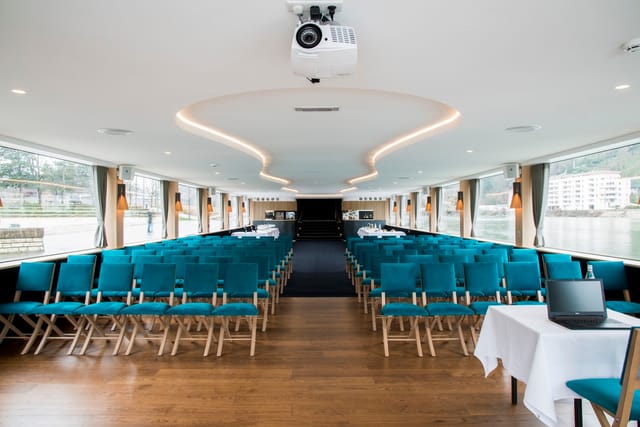 Bateau restaurant Hermès II: modern event space with teal chairs, perfect for meetings and presentations.