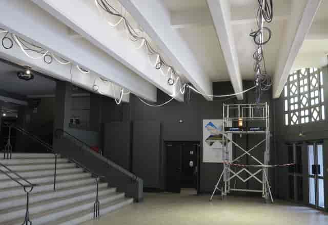 Spacious Théâtre de la Croix-Rousse hall with exposed ceilings, ideal for events and gatherings.