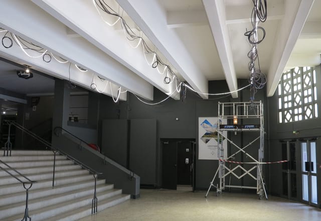 Spacious Théâtre de la Croix-Rousse hall with exposed ceilings, ideal for events and gatherings.