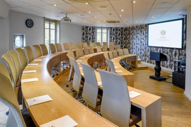 Modern meeting space at Châteauform' with semi-circular seating for corporate discussions.