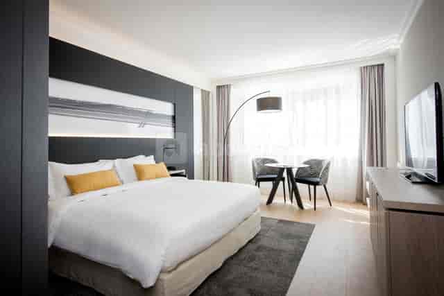 Modern hotel suite in Lyon with king-sized bed, perfect for business events.